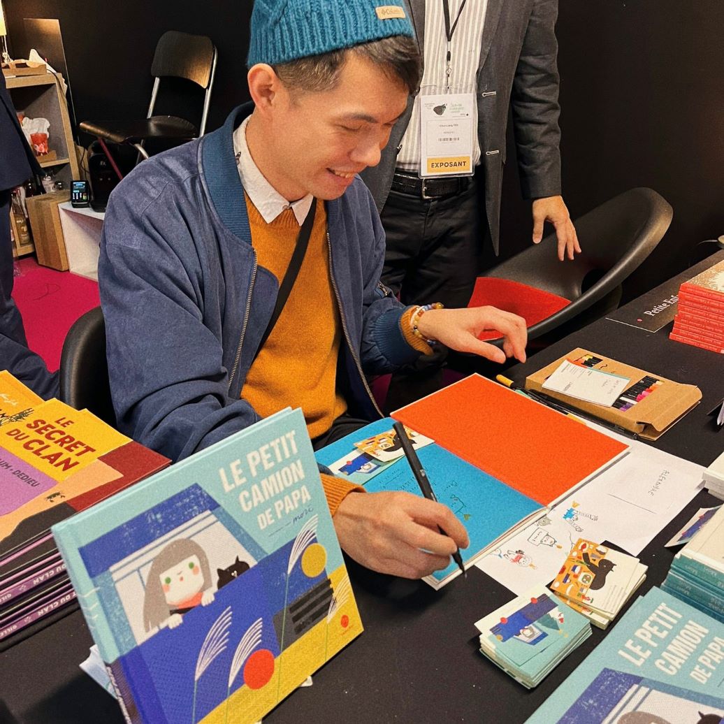 Signing books at Le Salon du Livre et de la Presse de Jeunesse.