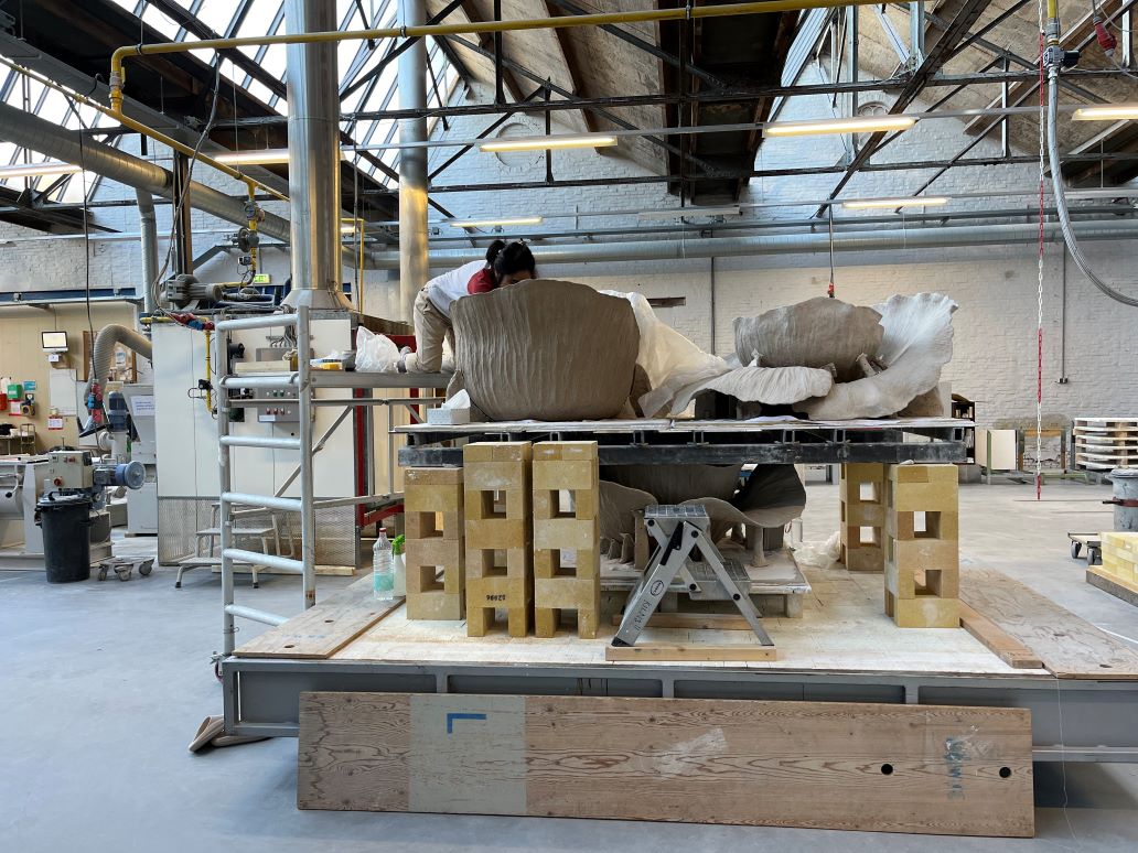 Fixing the clay body above a kiln, with the help of ladders.